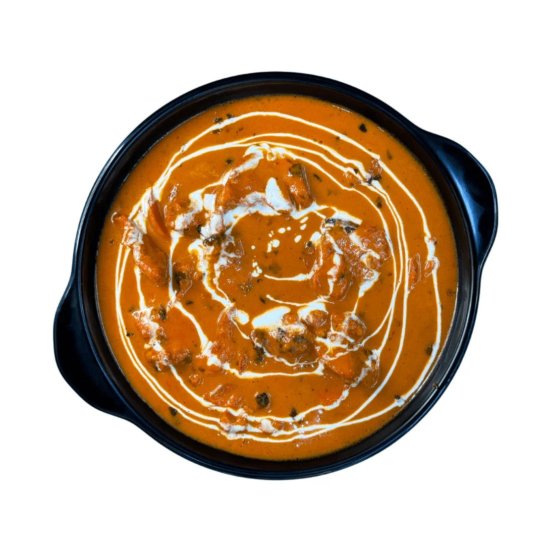 Butter Chicken: Creamy tomato-based curry with tender chicken pieces, garnished with fresh cream